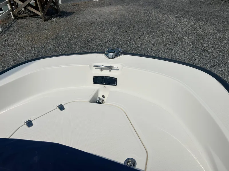 Slide: The Image of 2018 Boston Whaler 150 Montauk boat interior, featuring a clean, white deck and storage compartments. - 14