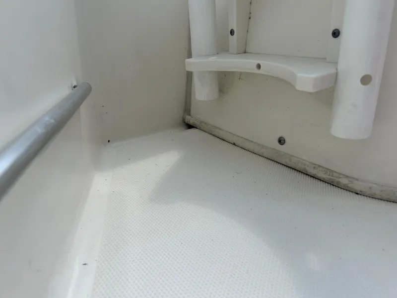 Slide: The Image of Interior view of a 2018 Boston Whaler 150 Montauk boat, showing seating and railing. - 15