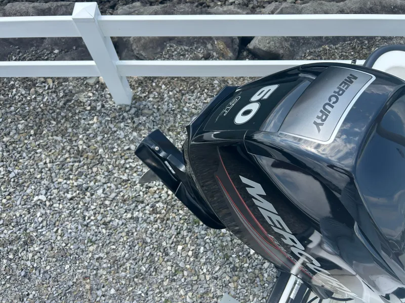 Slide: The Image of Mercury 60 HP outboard motor on 2018 Boston Whaler 150 Montauk, gravel background. - 20