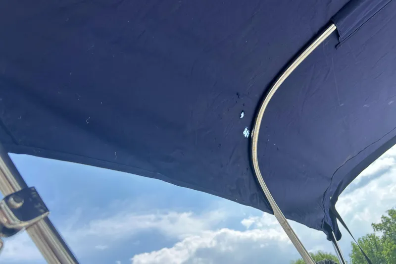 Slide: The Image of Blue canopy of a 2018 Boston Whaler 150 Montauk boat against a cloudy sky. - 6