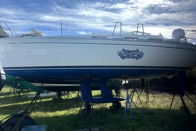 Slide: The Image of 2007 Bavaria 30 Cruiser sailboat named "My Serenity" on stands, under a blue sky. - 1