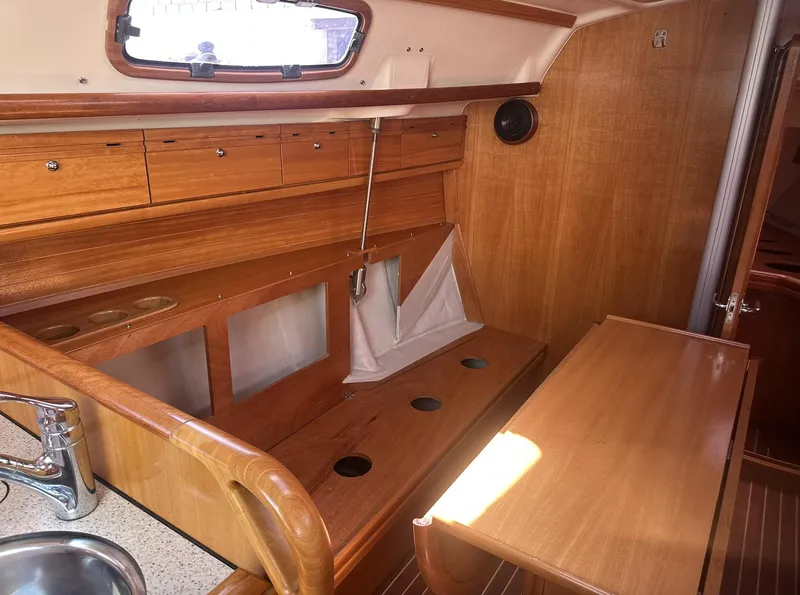 Slide: The Image of Interior of 2007 Bavaria 30 Cruiser sailboat with wooden cabinetry and seating area. - 10
