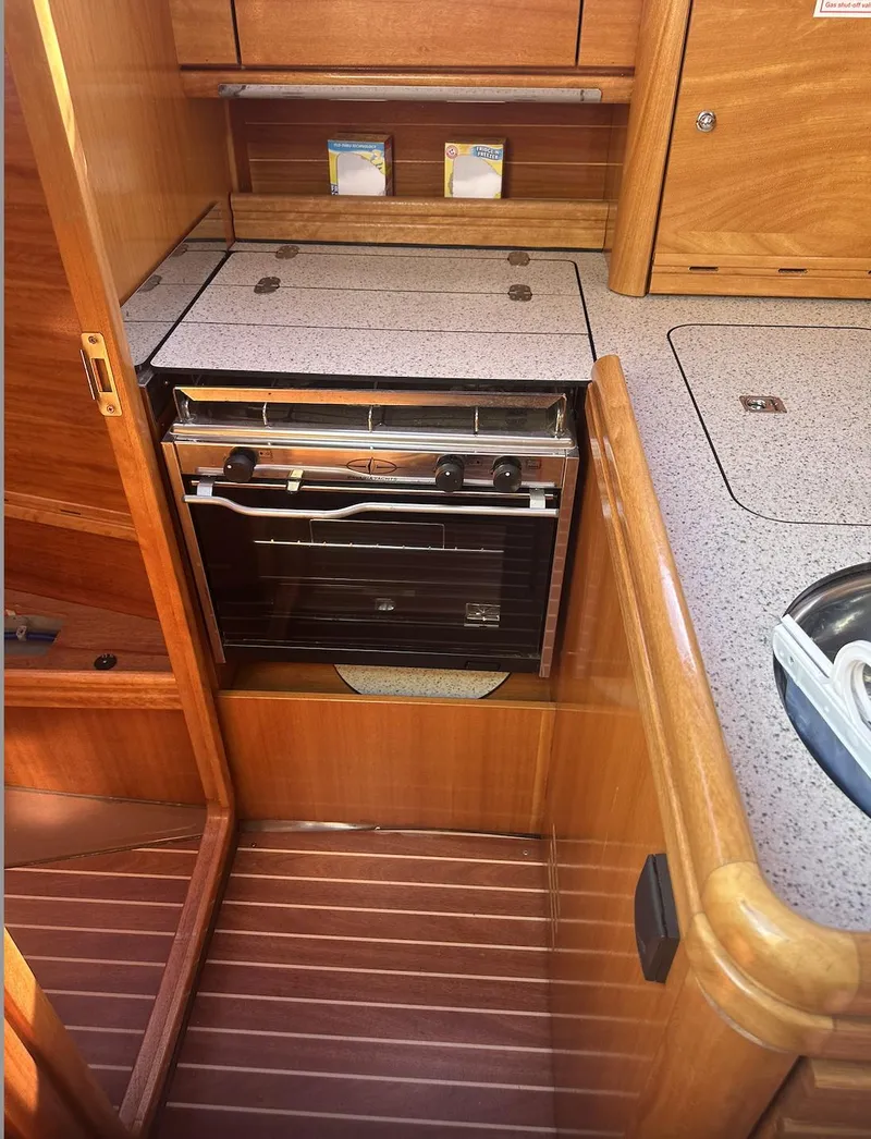 Slide: The Image of 2007 Bavaria 30 Cruiser yacht kitchen with stove and wooden cabinetry. - 15