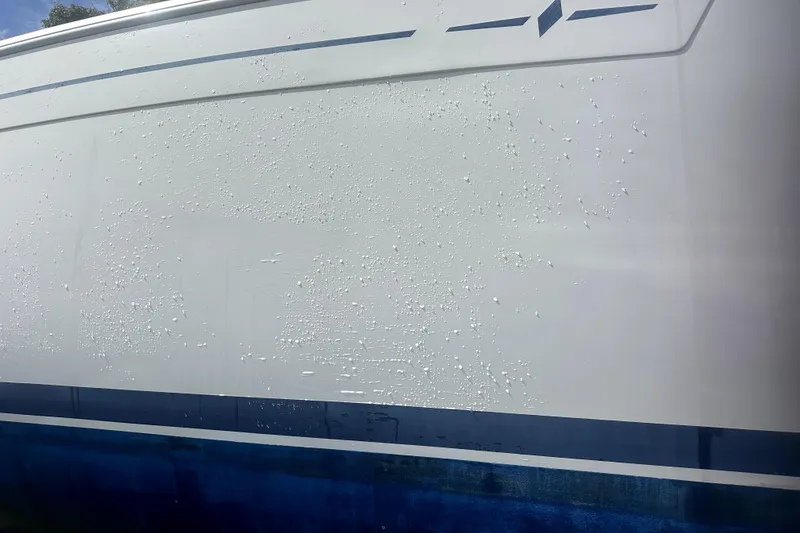 Slide: The Image of 2007 Bavaria 30 Cruiser hull with visible paint blistering and wear. - 19