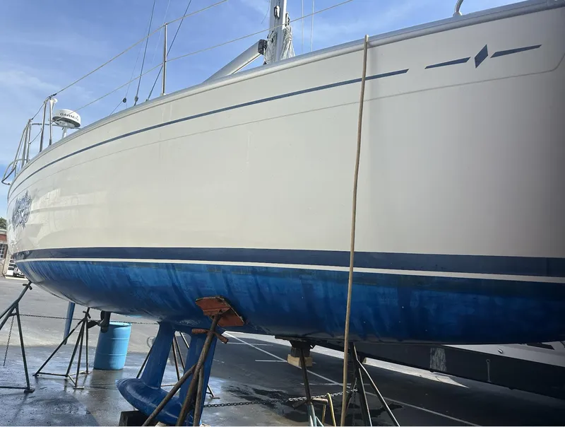 Slide: The Image of 2007 Bavaria 30 Cruiser sailboat on stands, blue hull, clear sky background. - 2