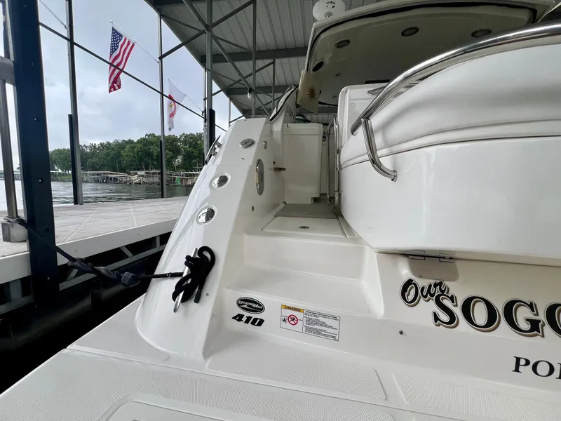 Slide: The Image of 2014 Sea Ray 410 Sundancer docked, featuring sleek design and American flags in the background. - 13