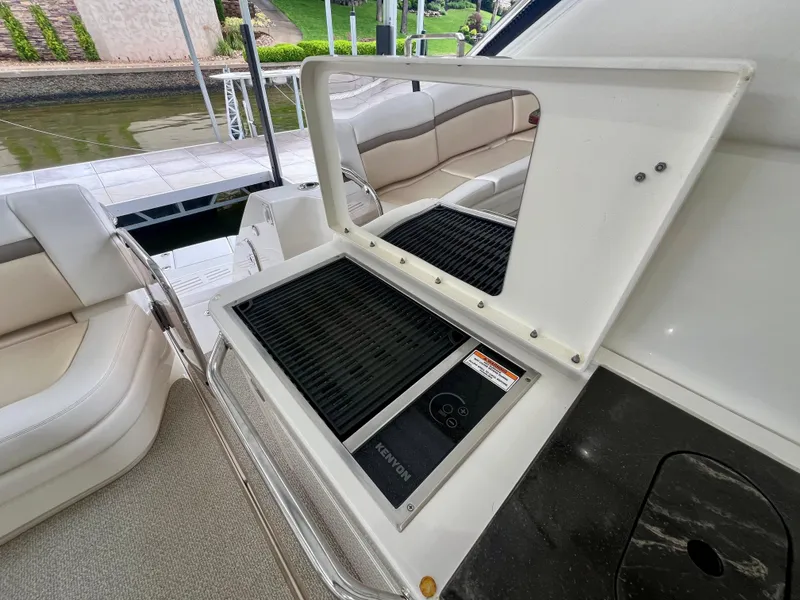 Slide: The Image of Outdoor grill on 2014 Sea Ray 410 Sundancer yacht, docked by a serene waterfront. - 19