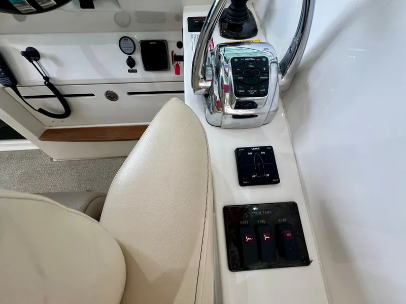 Slide: The Image of Helm controls of a 2014 Sea Ray 410 Sundancer boat, featuring throttle and trim tab switches. - 24