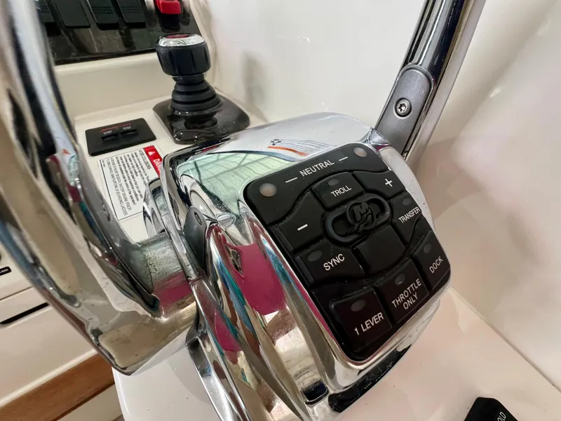 Slide: The Image of Control panel of a 2014 Sea Ray 410 Sundancer boat, featuring throttle and joystick controls. - 25