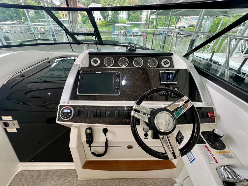 Slide: The Image of Helm of 2014 Sea Ray 410 Sundancer with modern controls and navigation system. - 29
