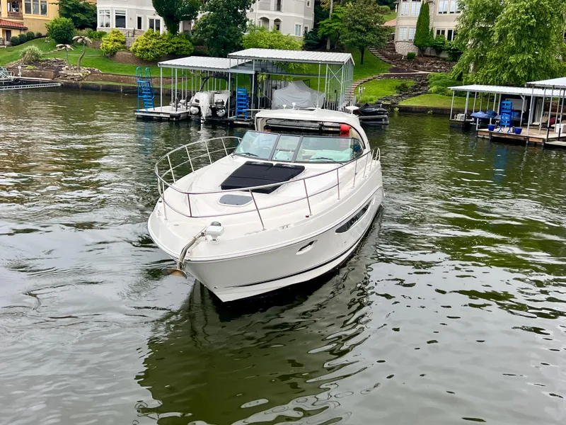 Slide: The Image of 2014 Sea Ray 410 Sundancer yacht on a calm lake near docks and waterfront homes. - 3