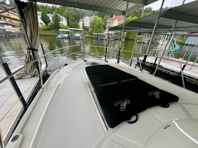 Slide: The Image of 2014 Sea Ray 410 Sundancer yacht docked, featuring spacious deck and scenic waterfront view. - 33