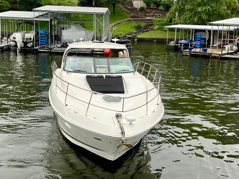 Slide: The Image of 2014 Sea Ray 410 Sundancer yacht docked in a marina, surrounded by lush greenery. - 4