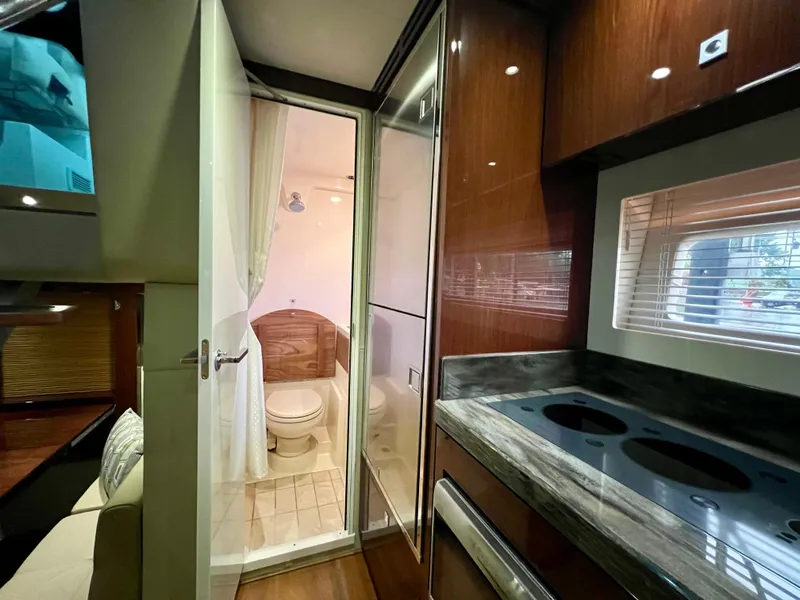 Slide: The Image of Interior of 2014 Sea Ray 410 Sundancer yacht, featuring kitchen and bathroom area. - 41