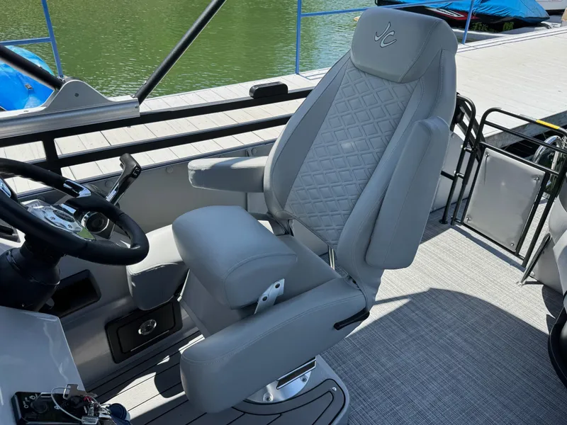 Slide: The Image of 2026 JC Neptoon Sport 23TT boat interior with luxury captain's chair and steering wheel. - 17