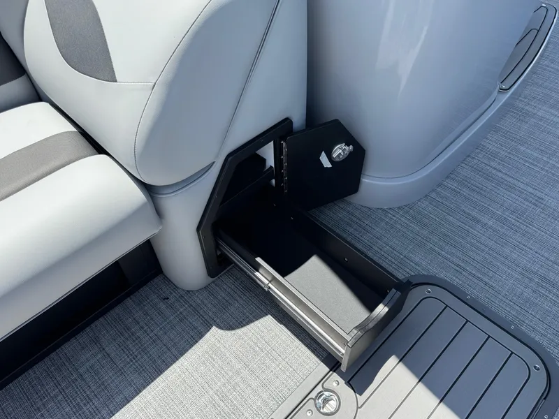 Slide: The Image of 2026 JC Neptoon Sport 23TT boat interior with open storage compartment and sleek seating. - 7