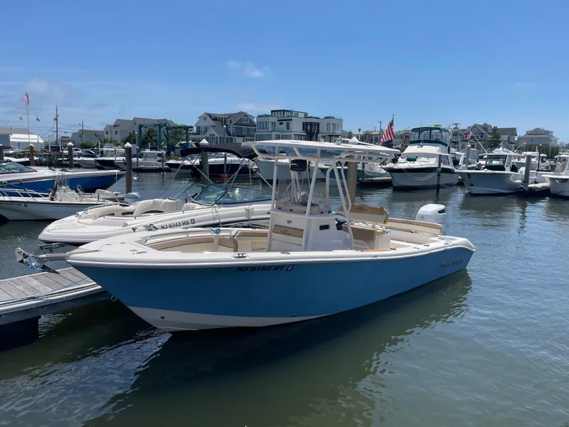Slide: The Image of 2023 Sea Chaser 24 HFC boat docked in a marina under clear blue skies. - 0