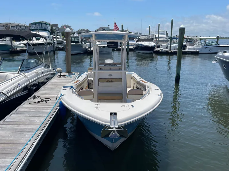 Slide: The Image of 2023 Sea Chaser 24 HFC boat docked at marina, clear sky background. - 1