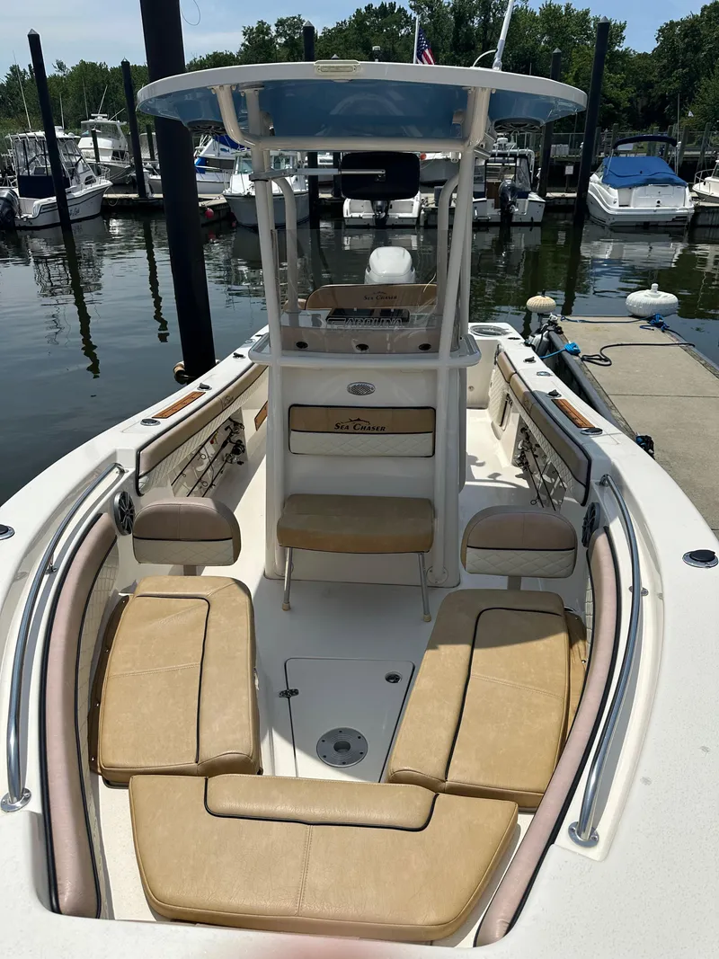 Slide: The Image of 2023 Sea Chaser 24 HFC boat with tan seating, docked at marina. - 11