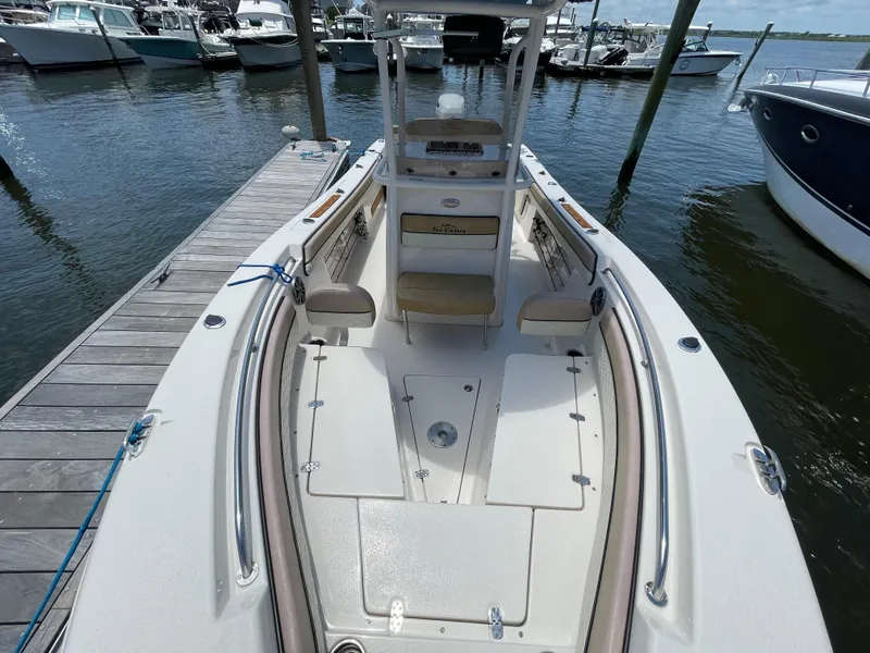 Slide: The Image of 2023 Sea Chaser 24 HFC boat docked at marina, showcasing spacious deck and seating. - 12