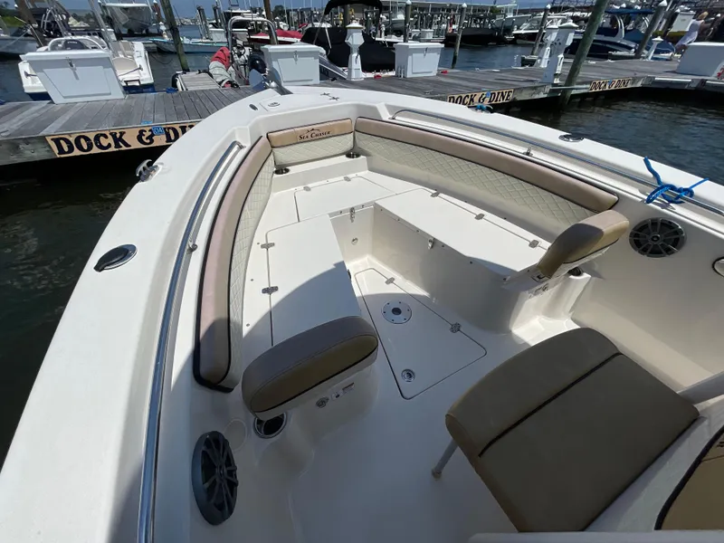 Slide: The Image of 2023 Sea Chaser 24 HFC boat interior at dock, featuring seating and storage. - 14