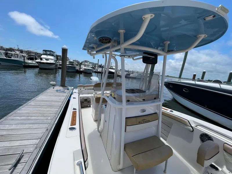 Slide: The Image of 2023 Sea Chaser 24 HFC boat docked at a marina under a clear blue sky. - 19