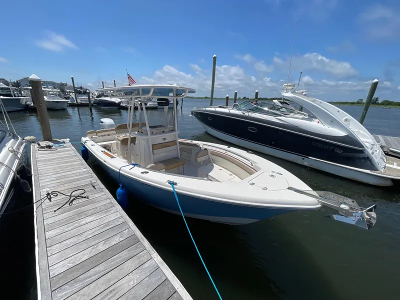 Slide: The Image of 2023 Sea Chaser 24 HFC boat docked at marina under clear blue sky. - 2