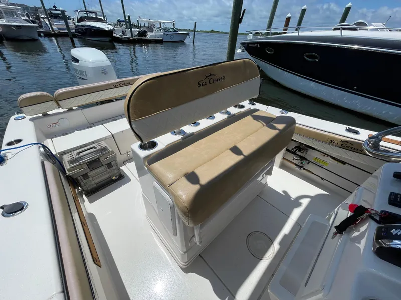 Slide: The Image of 2023 Sea Chaser 24 HFC boat interior with seating and storage, docked at marina. - 21