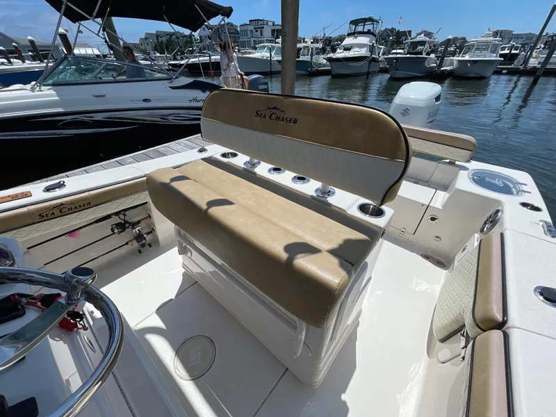 Slide: The Image of 2023 Sea Chaser 24 HFC boat interior with tan seating at marina. - 23