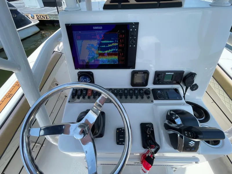 Slide: The Image of 2023 Sea Chaser 24 HFC boat dashboard with steering wheel and navigation controls. - 26