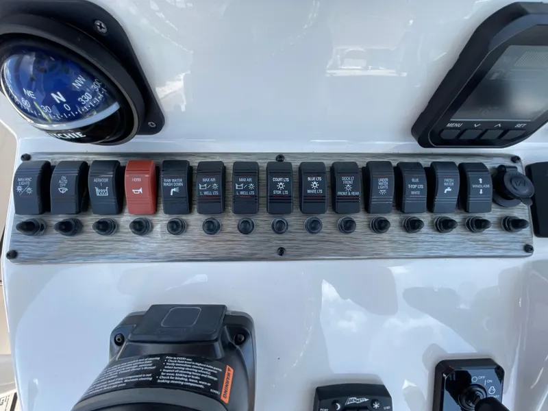 Slide: The Image of Control panel of 2023 Sea Chaser 24 HFC boat with various switches and compass. - 29
