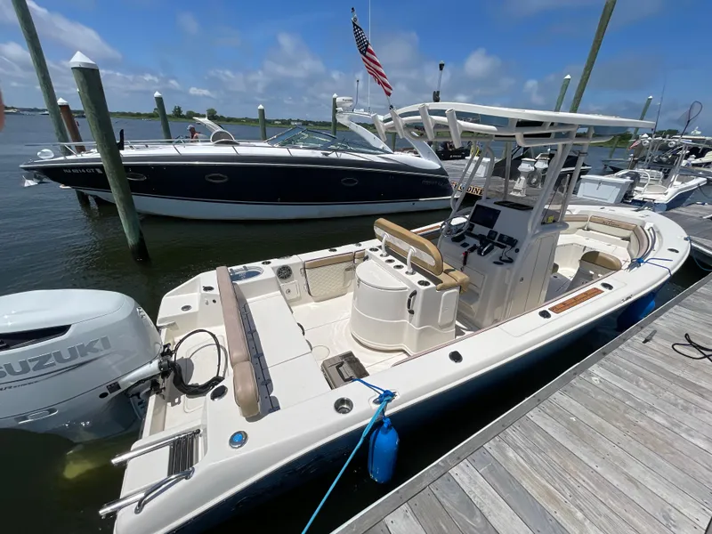 Slide: The Image of 2023 Sea Chaser 24 HFC boat docked, featuring Suzuki outboard motor, under clear skies. - 3
