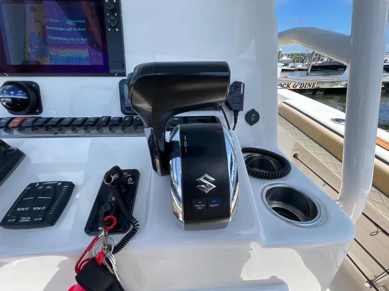 Slide: The Image of 2023 Sea Chaser 24 HFC boat dashboard with Suzuki throttle control and navigation display. - 32