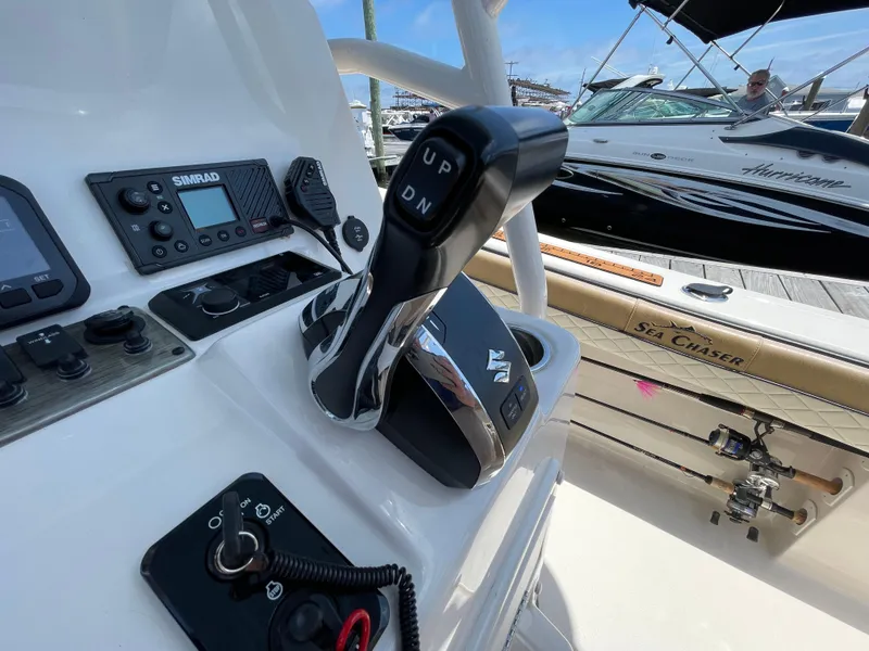 Slide: The Image of 2023 Sea Chaser 24 HFC boat controls and dashboard with fishing rods. - 33