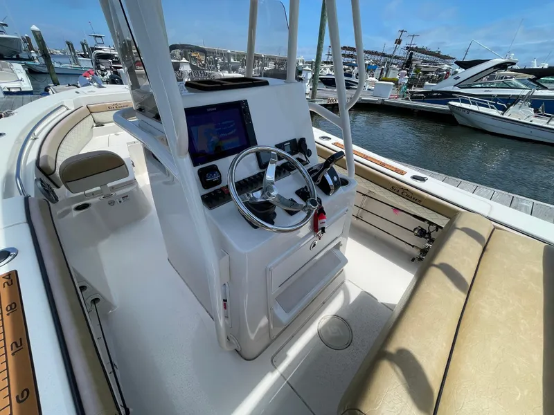 Slide: The Image of 2023 Sea Chaser 24 HFC boat interior with steering console and seating at marina. - 35