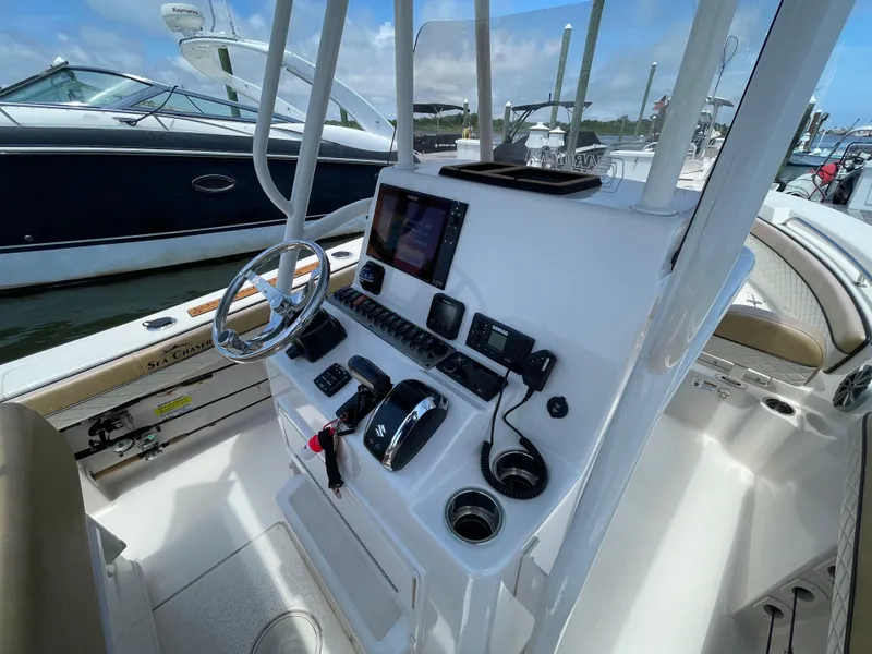 Slide: The Image of 2023 Sea Chaser 24 HFC boat dashboard with steering wheel and navigation controls. - 36