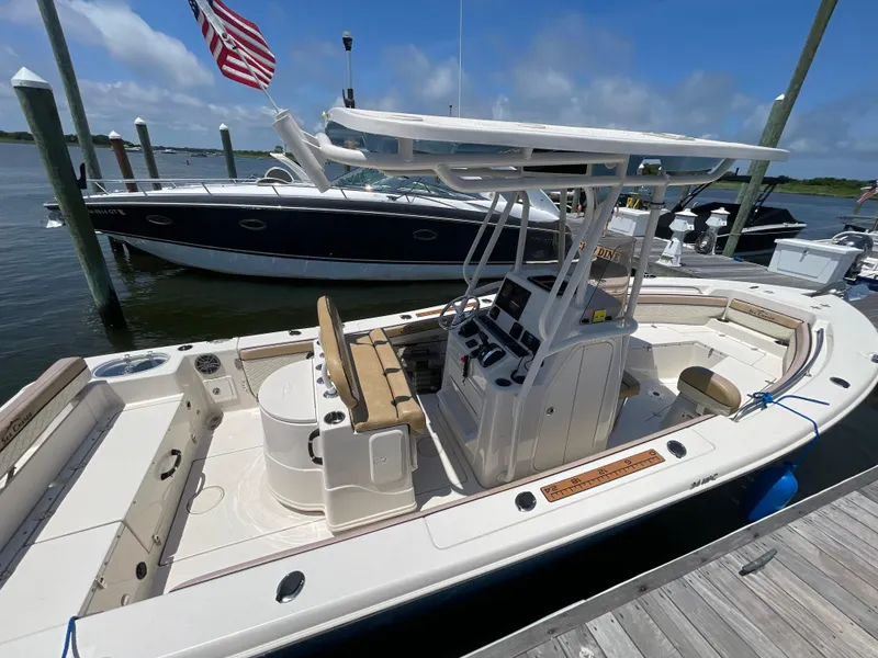 Slide: The Image of 2023 Sea Chaser 24 HFC boat docked, featuring spacious deck and modern controls. - 4