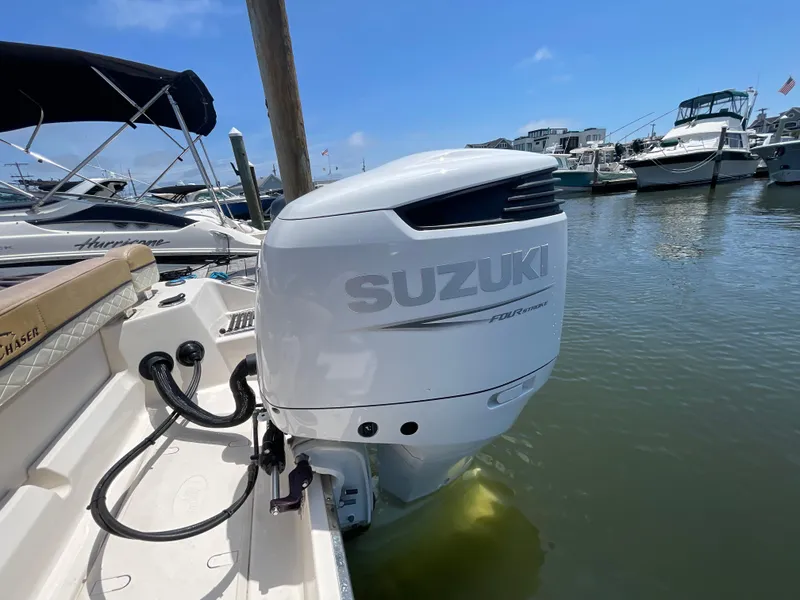 Slide: The Image of 2023 Sea Chaser 24 HFC with Suzuki outboard motor docked in marina. - 49