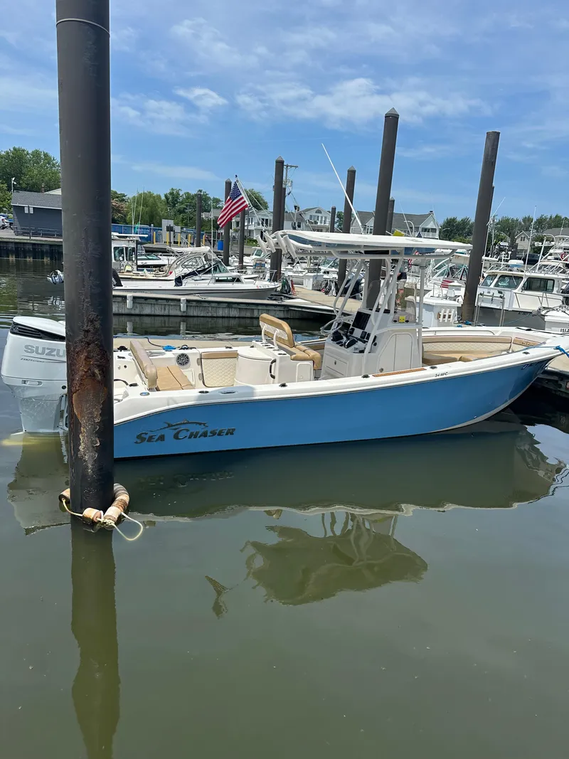 Slide: The Image of 2023 Sea Chaser 24 HFC boat docked in a marina, clear sky background. - 5
