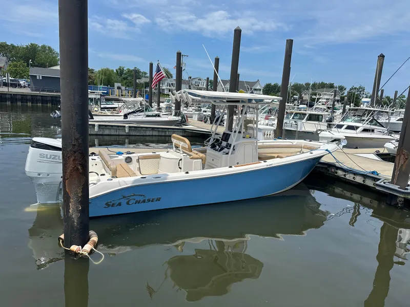 Slide: The Image of 2023 Sea Chaser 24 HFC boat docked in a marina with clear skies. - 6