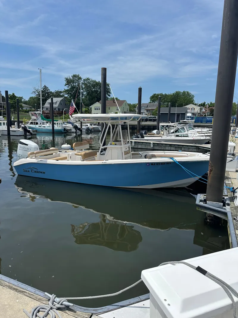 Slide: The Image of 2023 Sea Chaser 24 HFC boat docked in a marina under a clear blue sky. - 7