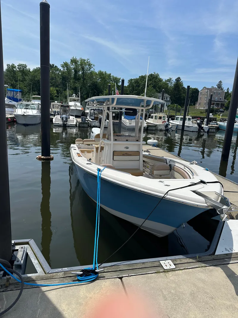 Slide: The Image of 2023 Sea Chaser 24 HFC boat docked at a marina on a sunny day. - 8
