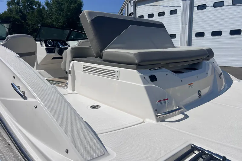 Slide: The Image of 2020 Sea Ray SPX 210 boat interior with seating and dashboard, parked near a garage. - 10