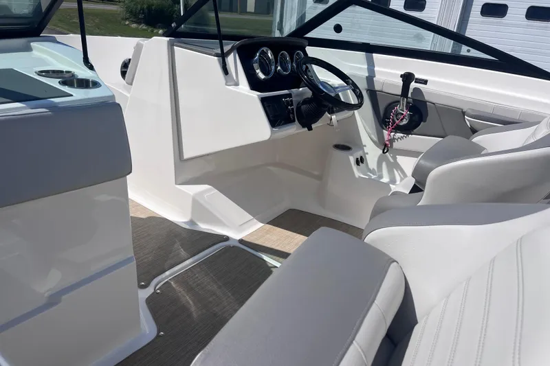 Slide: The Image of Interior of a 2020 Sea Ray SPX 210 boat, featuring sleek white seating and modern controls. - 22