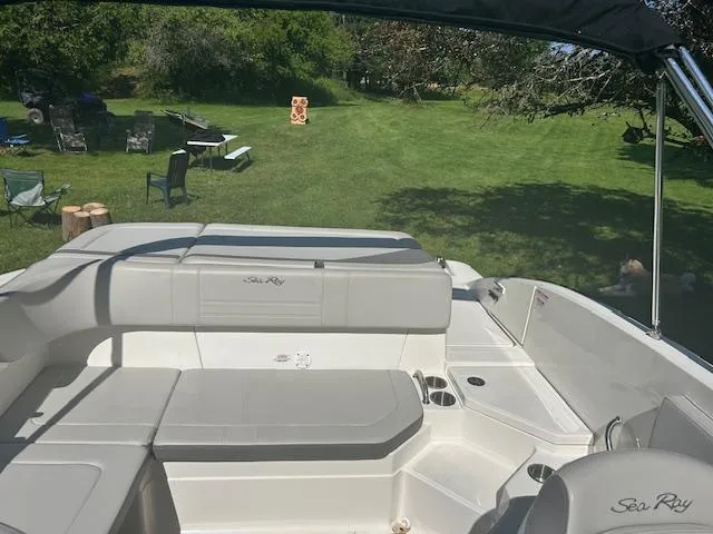 Slide: The Image of 2020 Sea Ray SPX 210 boat interior with seating, set in a grassy outdoor area. - 26