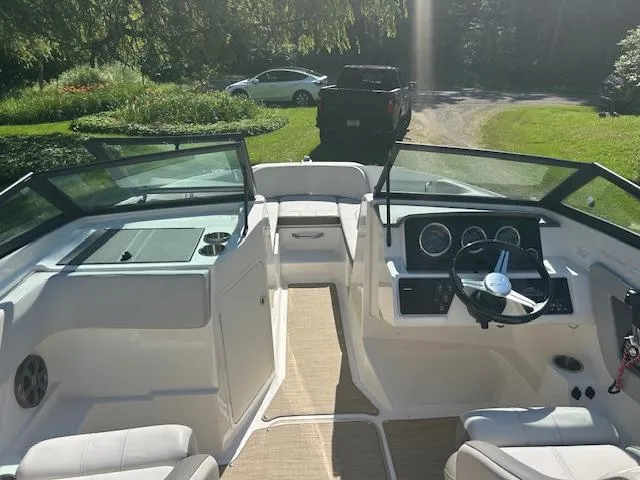 Slide: The Image of 2020 Sea Ray SPX 210 boat interior with steering wheel and seating, parked outdoors. - 28