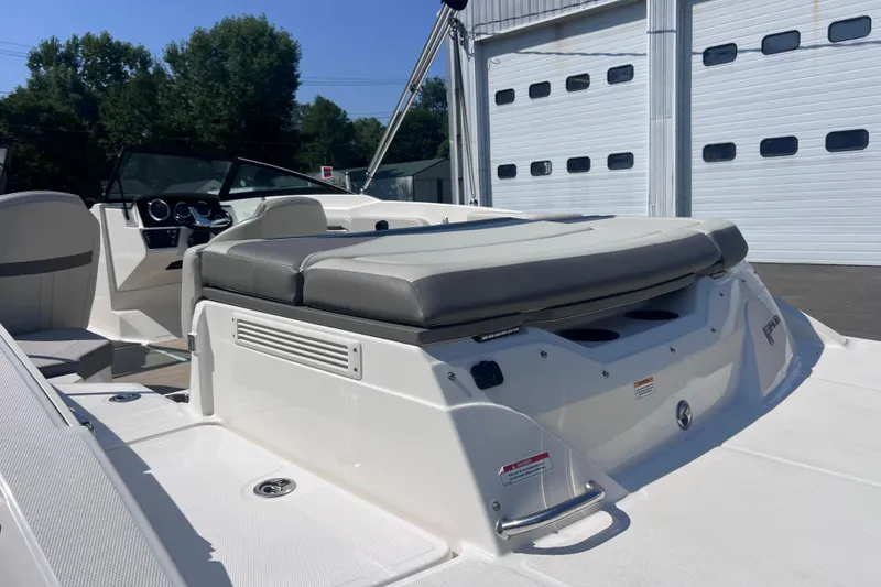 Slide: The Image of 2020 Sea Ray SPX 210 boat interior with seating and dashboard, parked near a garage. - 9
