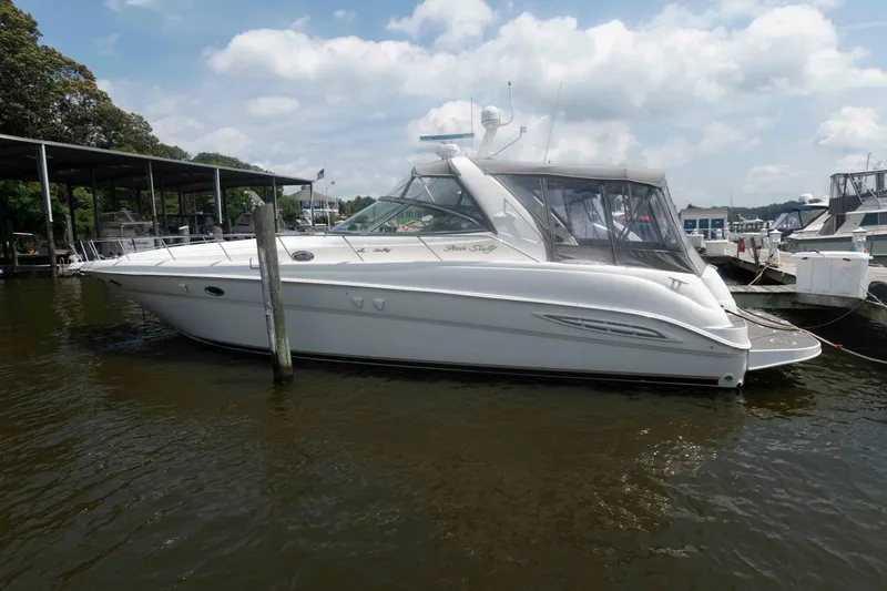 The Image of 2001 Sea Ray 460 Sundancer yacht docked in a marina under a partly cloudy sky. - 0