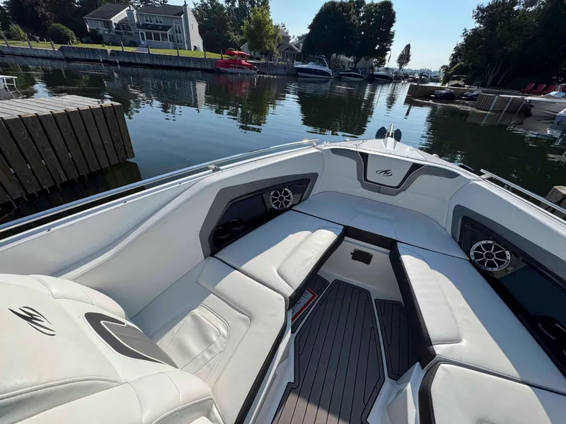 Slide: The Image of 2017 Monterey 328 Super Sport boat interior with white seating, docked in a serene waterfront setting. - 14