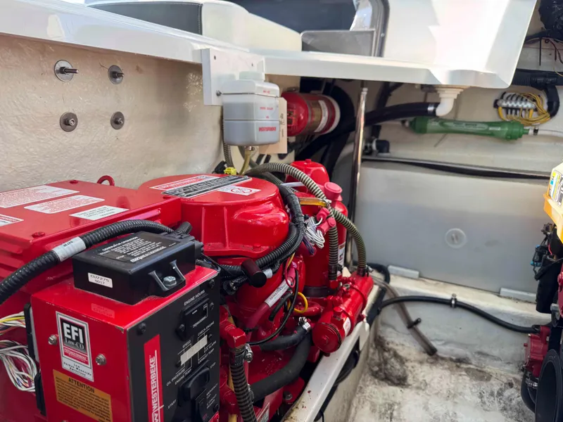 Slide: The Image of Engine compartment of a 2017 Monterey 328 Super Sport boat, featuring red engine components. - 21